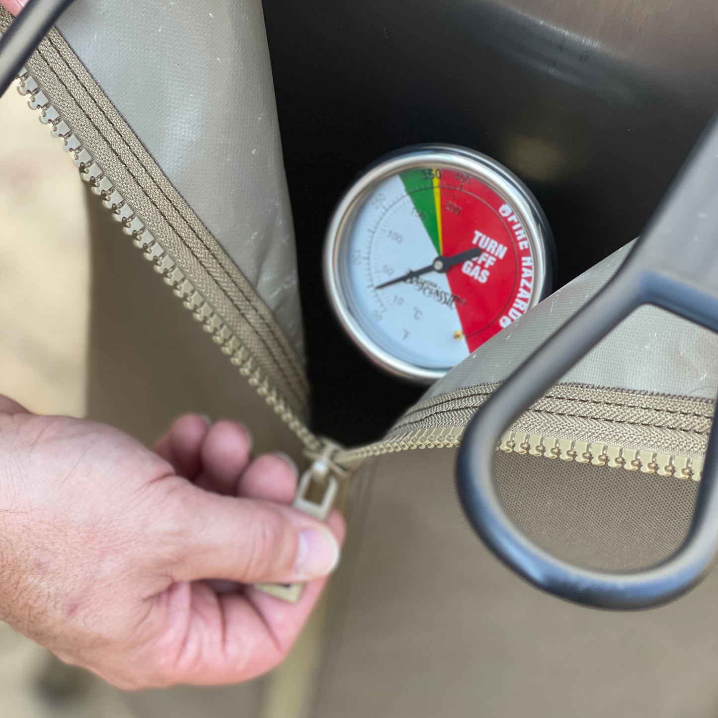 Close up of man unzipping 4-gal Bayou Fryer canvas cover