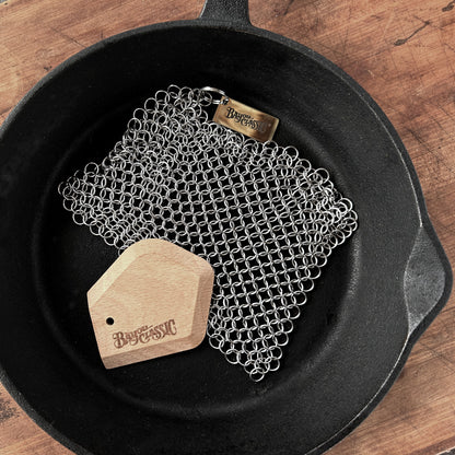 Chainmail scrubber and beech wood scrapper in a cast iron skillet