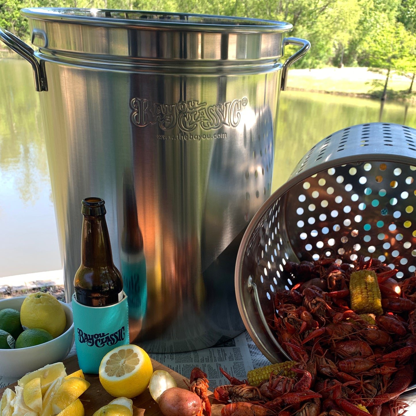 Stainless Stockpot with Basket dumping crawfish on a table by a body of water