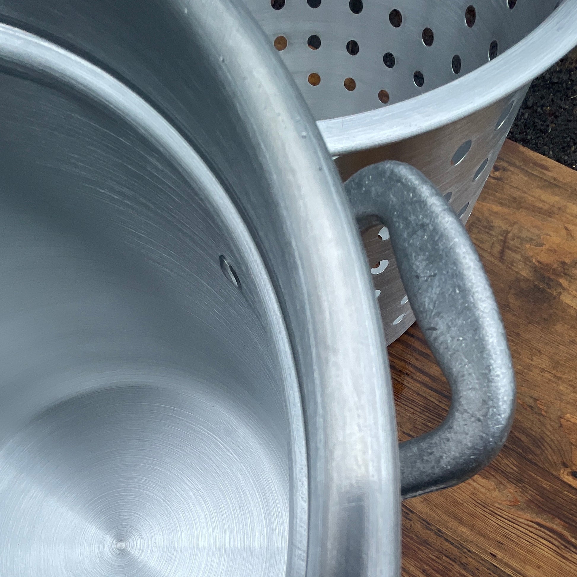Close up of aluminum stockpot handle with basket in the background