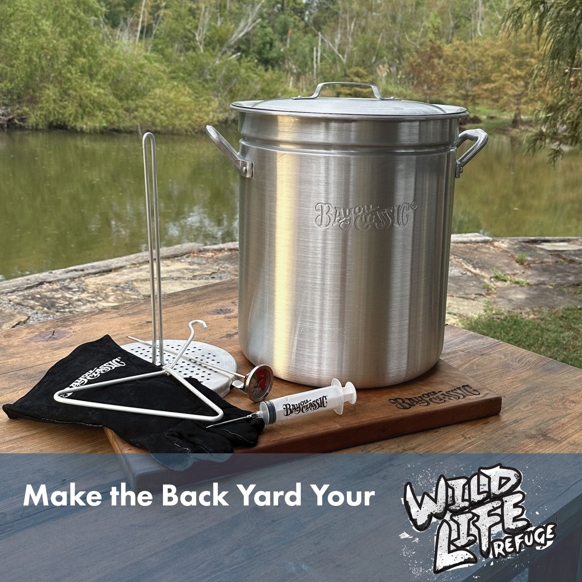 Aluminum Turkey Fryer Pot with accessories on a wooden surface by a body of water, featuring text that reads Make the Back Yard Your Wild Life Refuge
