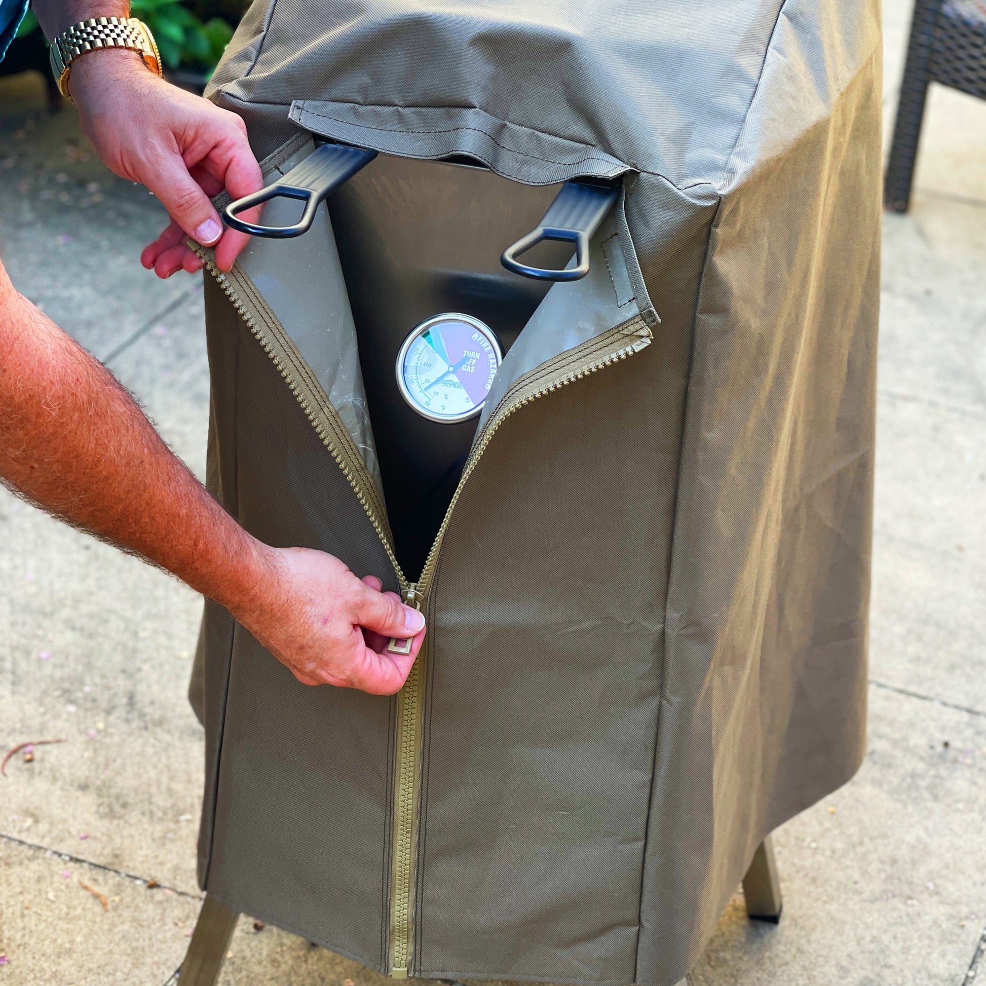 Man unzipping brown canvas cover to the 4-gal Bayou Fryer