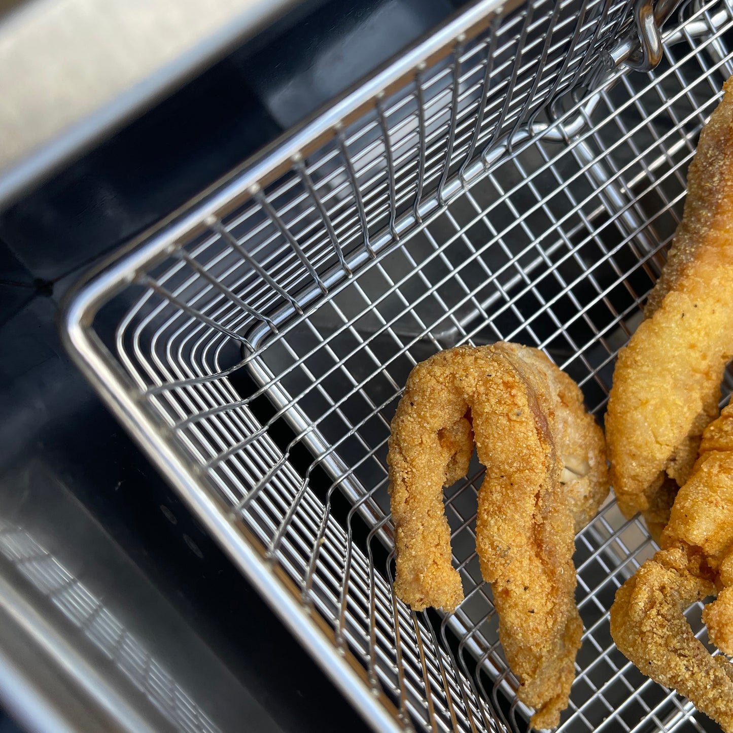 Close up image of Bayou Fryer basket with fried fish