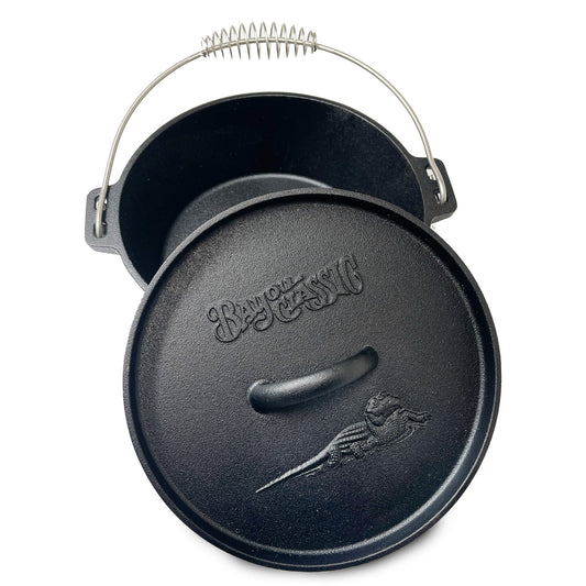 A black cast iron Dutch Oven with a flanged lid and a stainless coil wire handle grip. The lid features an embossed alligator logo on a white background.