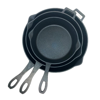 A set of three black cast iron skillets with handles, stacked together, in varying sizes on a white background