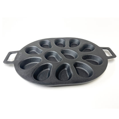 A black cast iron oyster grill pan with shellfish-shaped molds and two handles on a white background.