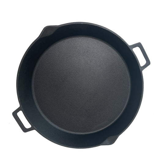 Overview of cast iron skillet with two helper handles on a white background