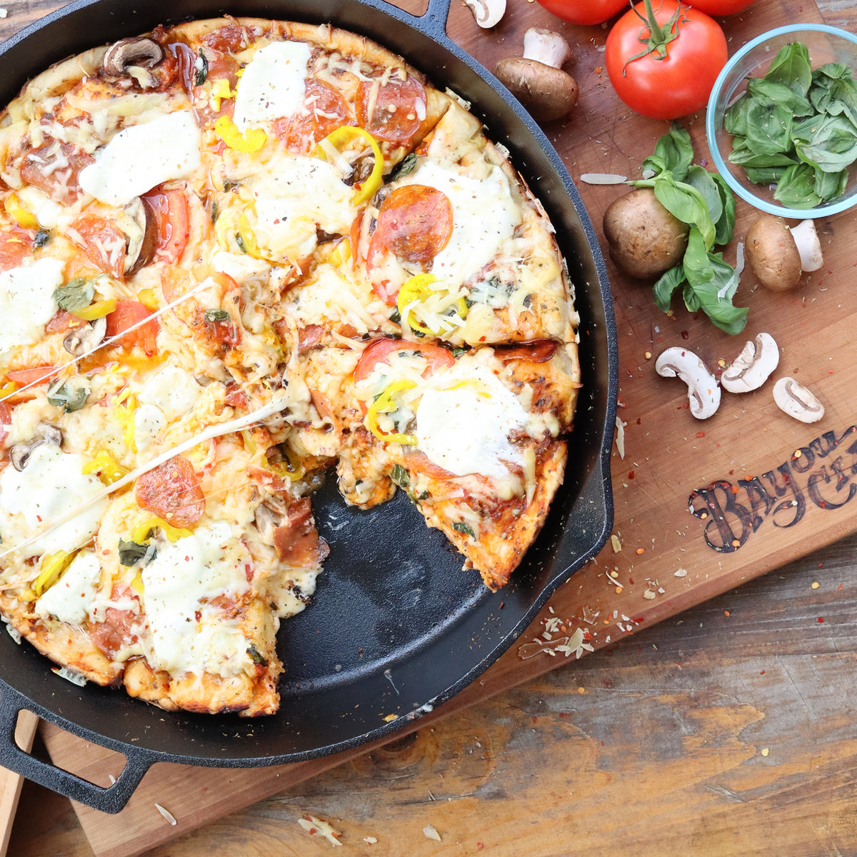 Large Cast Iron Skillet with a cooked pizza and fresh ingredients
