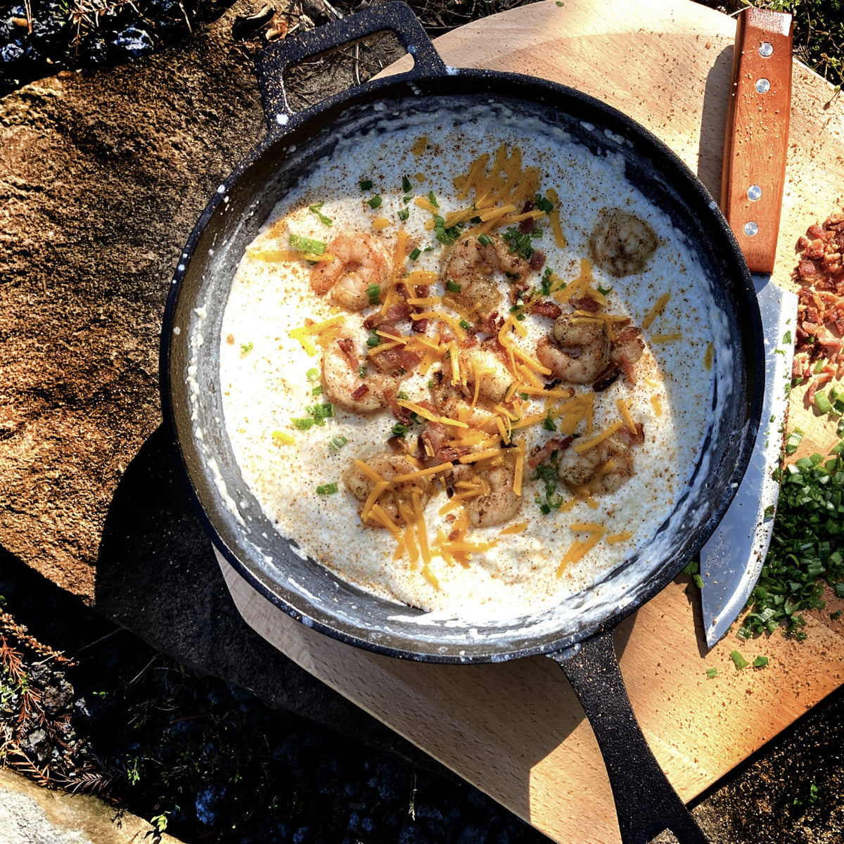 Cast iron skillet with shrimp bisque on an outdoor surface
