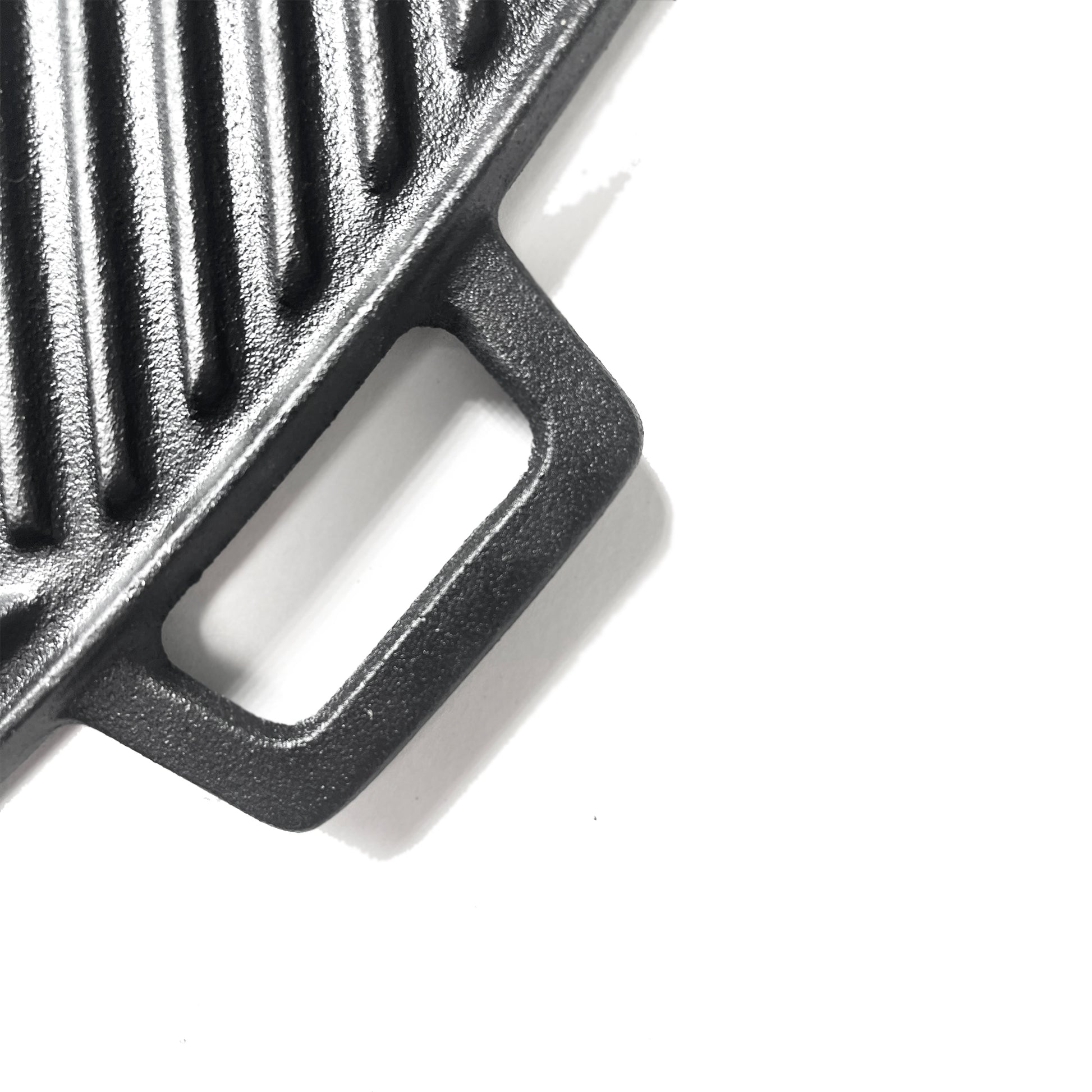 Close up of cast iron griddle handle on a white background