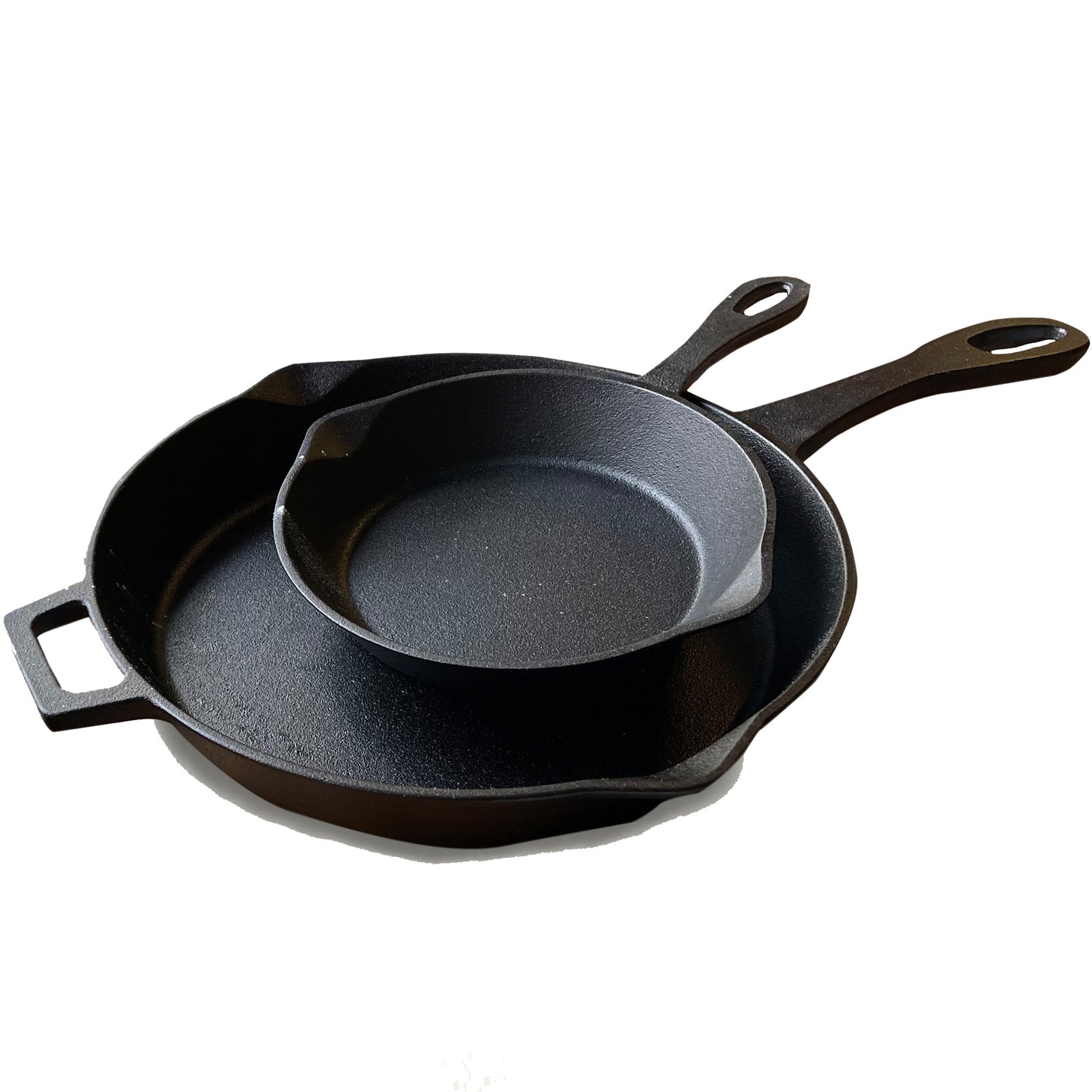 A set of two black cast iron skillets, one larger than the other, stacked inside each other on a white background.
