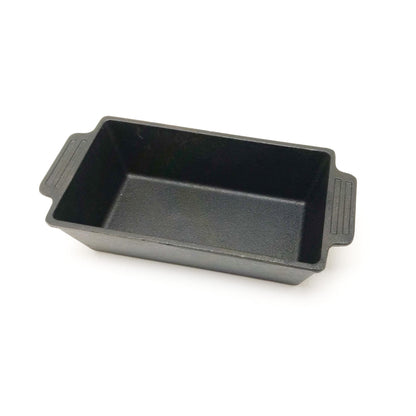 A black cast iron loaf pan with side handles, against a white background.