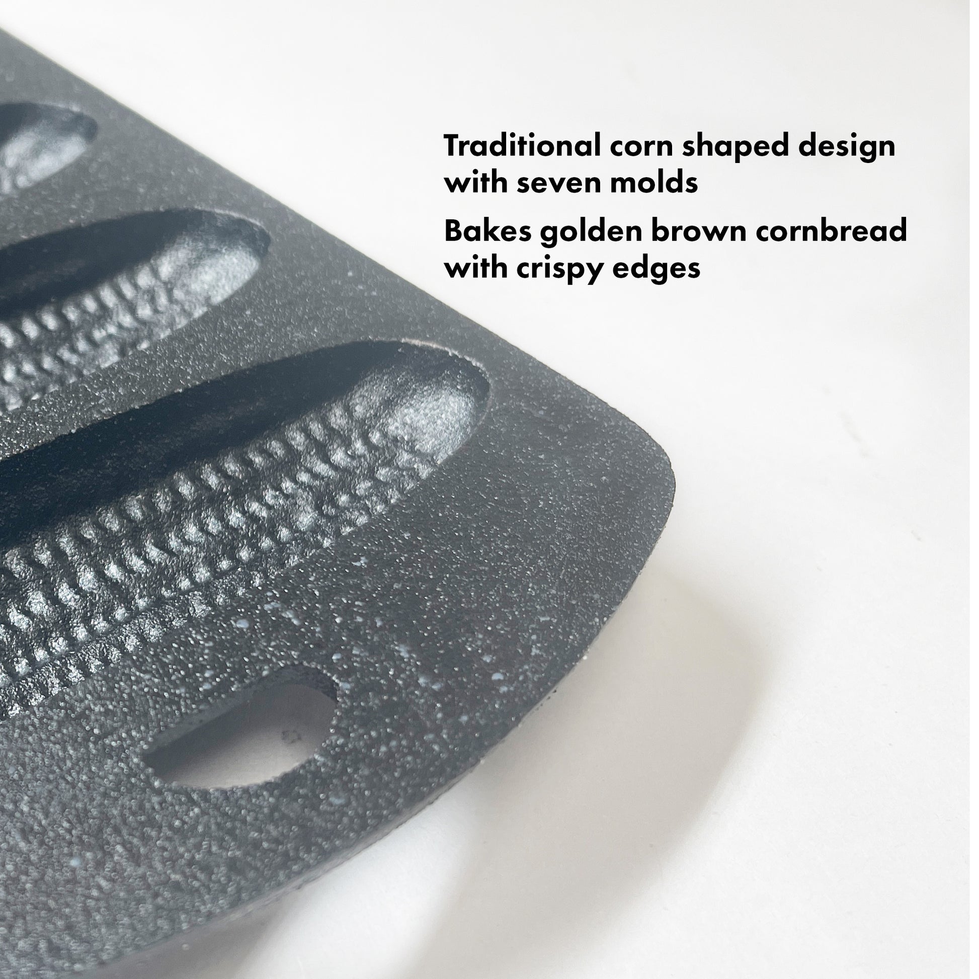 Close up image of cast iron cornbread pan on a white background.  Features read traditional corn shaped design with seven molds.  Bakes golden brown cornbread with crispy edges.