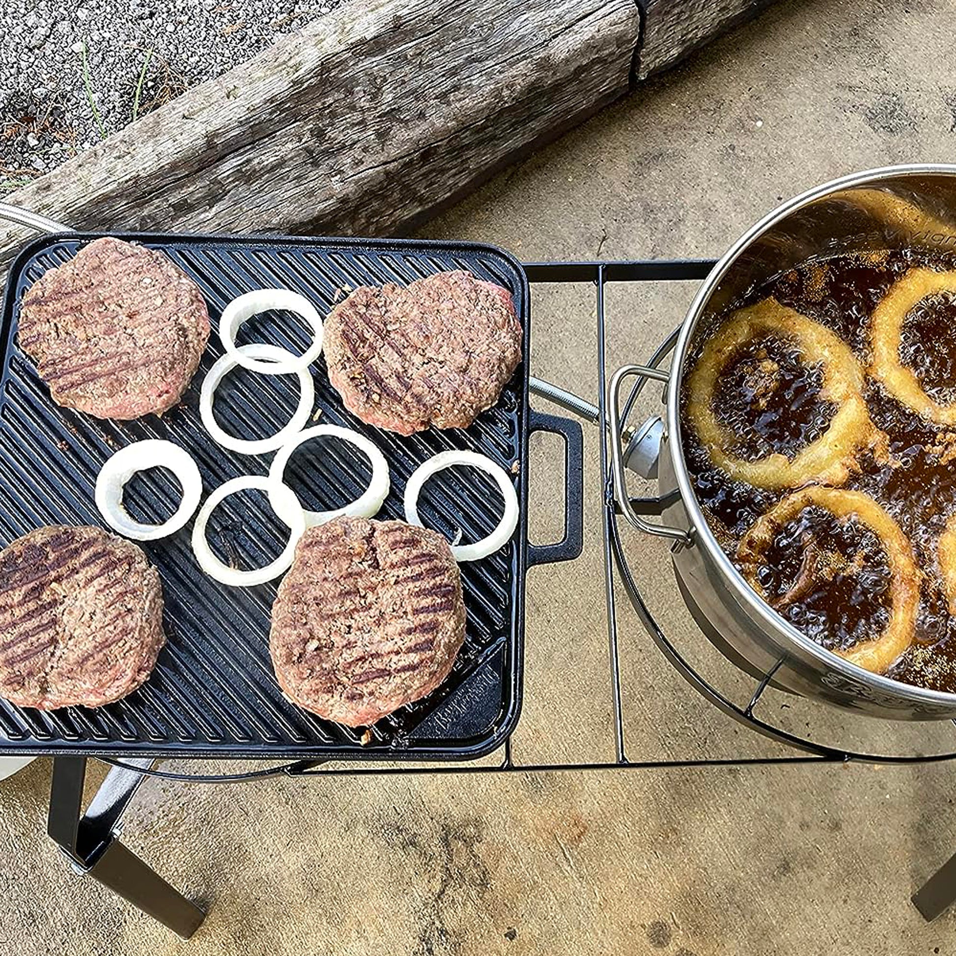 Cast Iron Griddle with burgers and fry pot with onion rings on an outdoor cooker