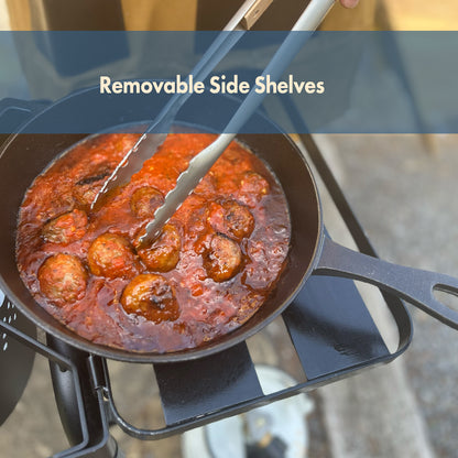 Cast iron skillet with meatballs on the side shelf of an outdoor cooker with teat that reads Removable Side Shelves