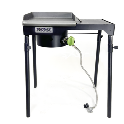 Portable camping outdoor cooker with a black base and steel griddle top on a white background