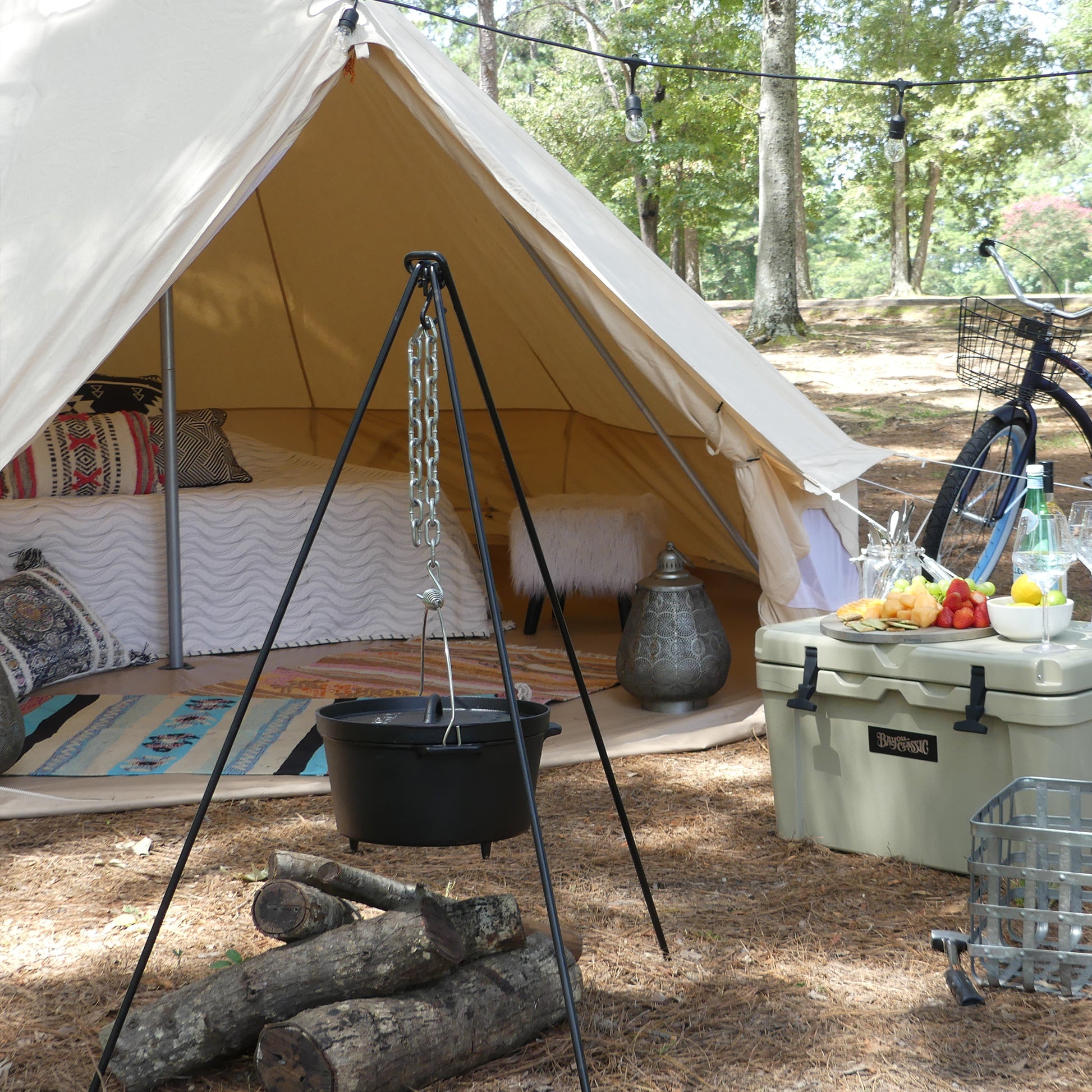 Glamping Campsite with a tent, cast iron pot, firewood, and a cooler