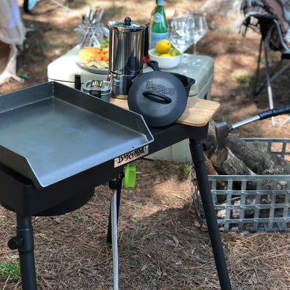 Patio Stove with griddle and small cast iron pot outside at a camp ground