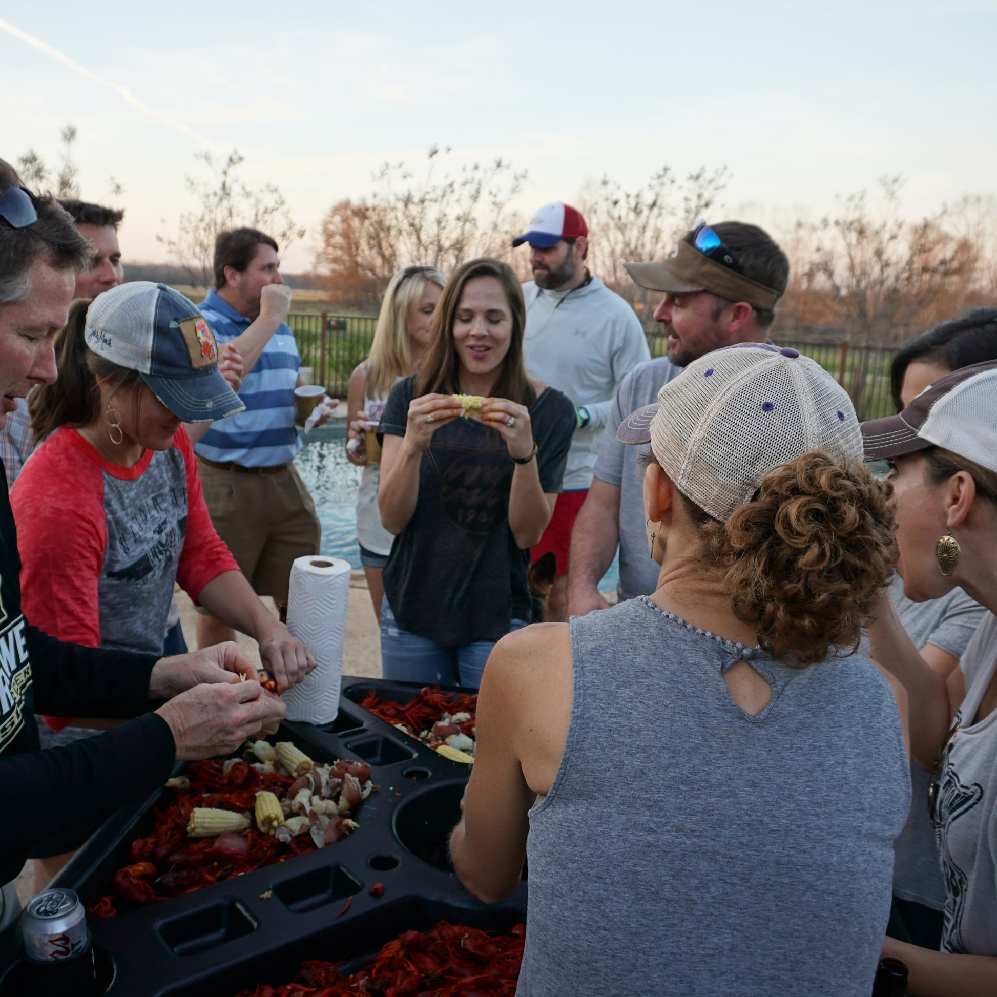 People outside around the seafood table eating crawfish